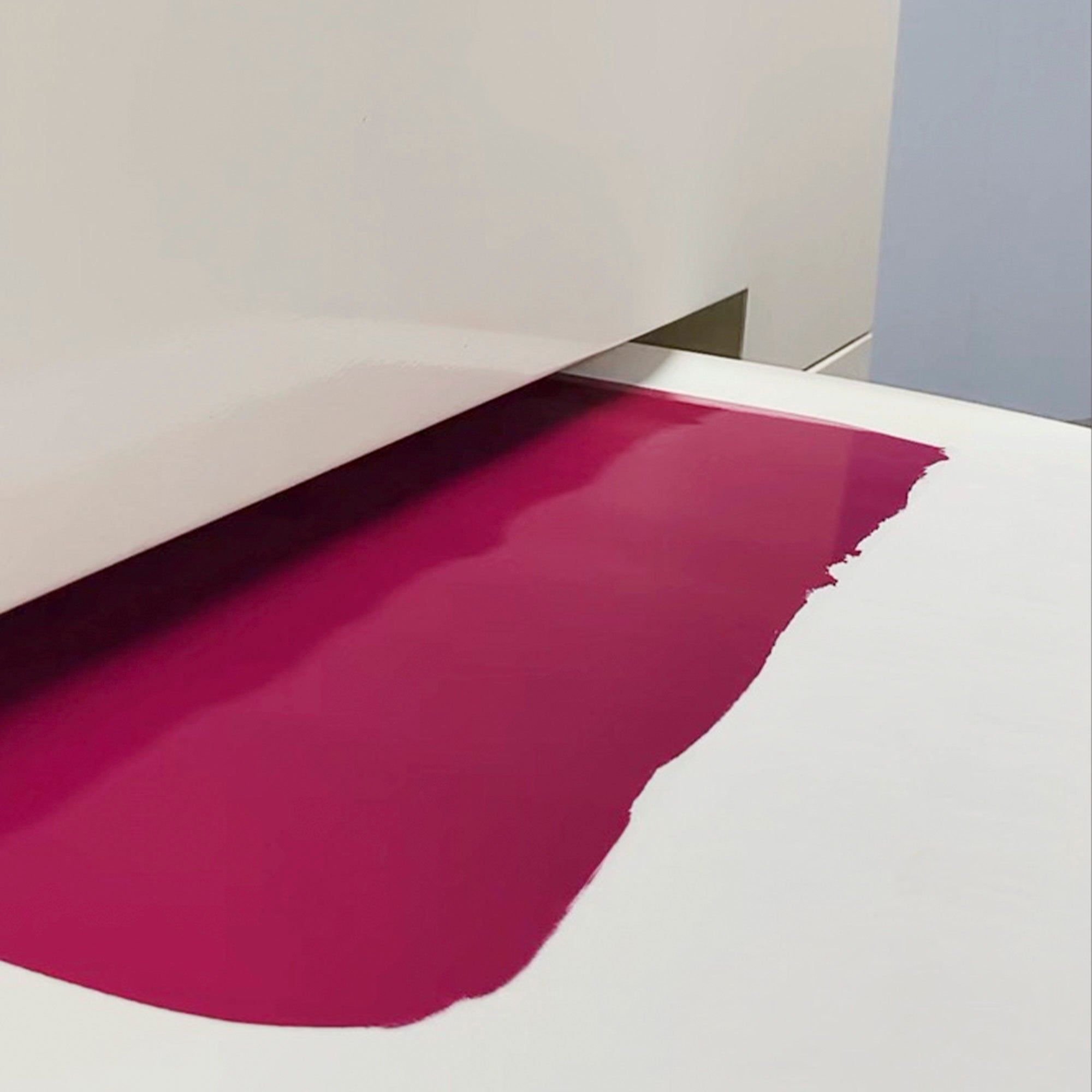 Close-up of a magenta leather coating on a white surface