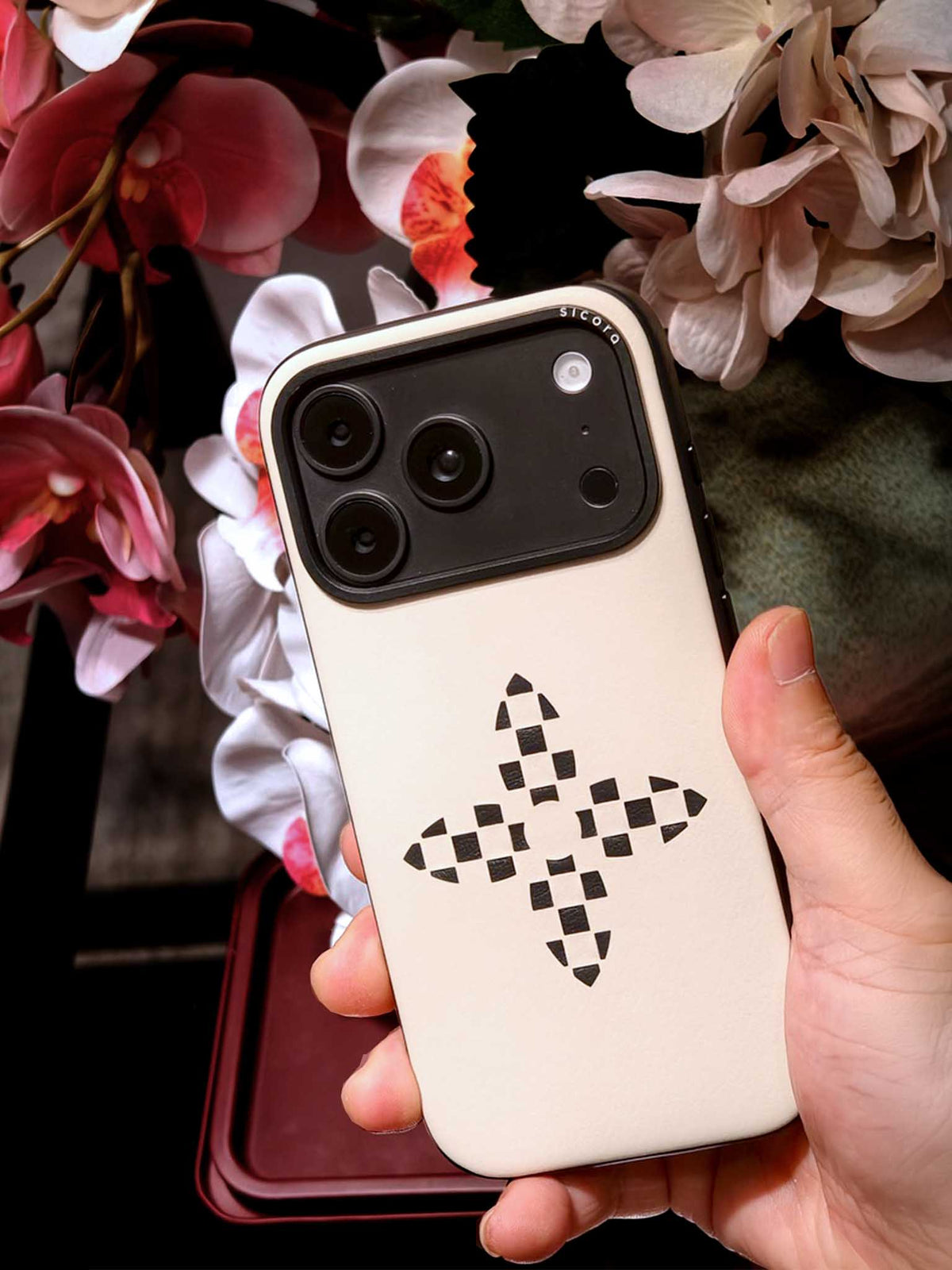 Hand holding a sicora iPhone 18 / 17  pro case, bloom case in white silio silicone vegan leather.