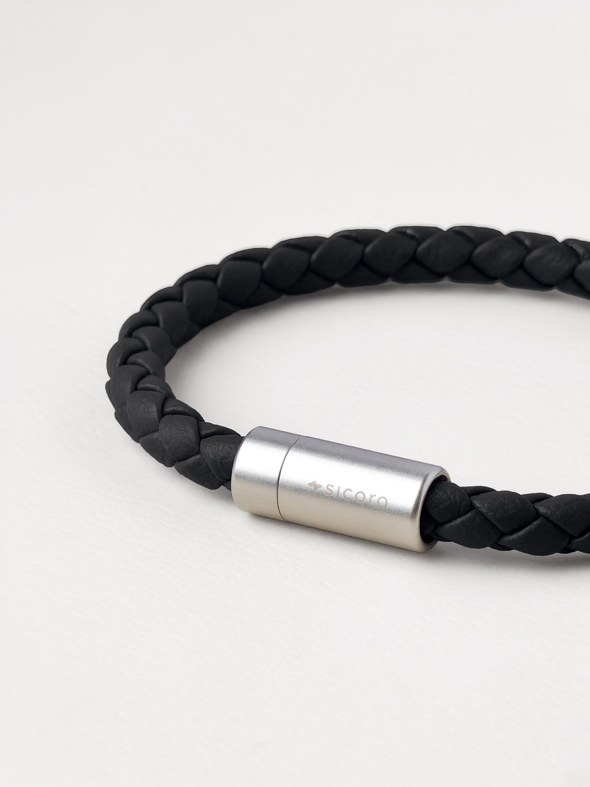 close-up of a sicora black braided silio silicone vegan leather bracelet with a stainless steel metal magnetic clasp