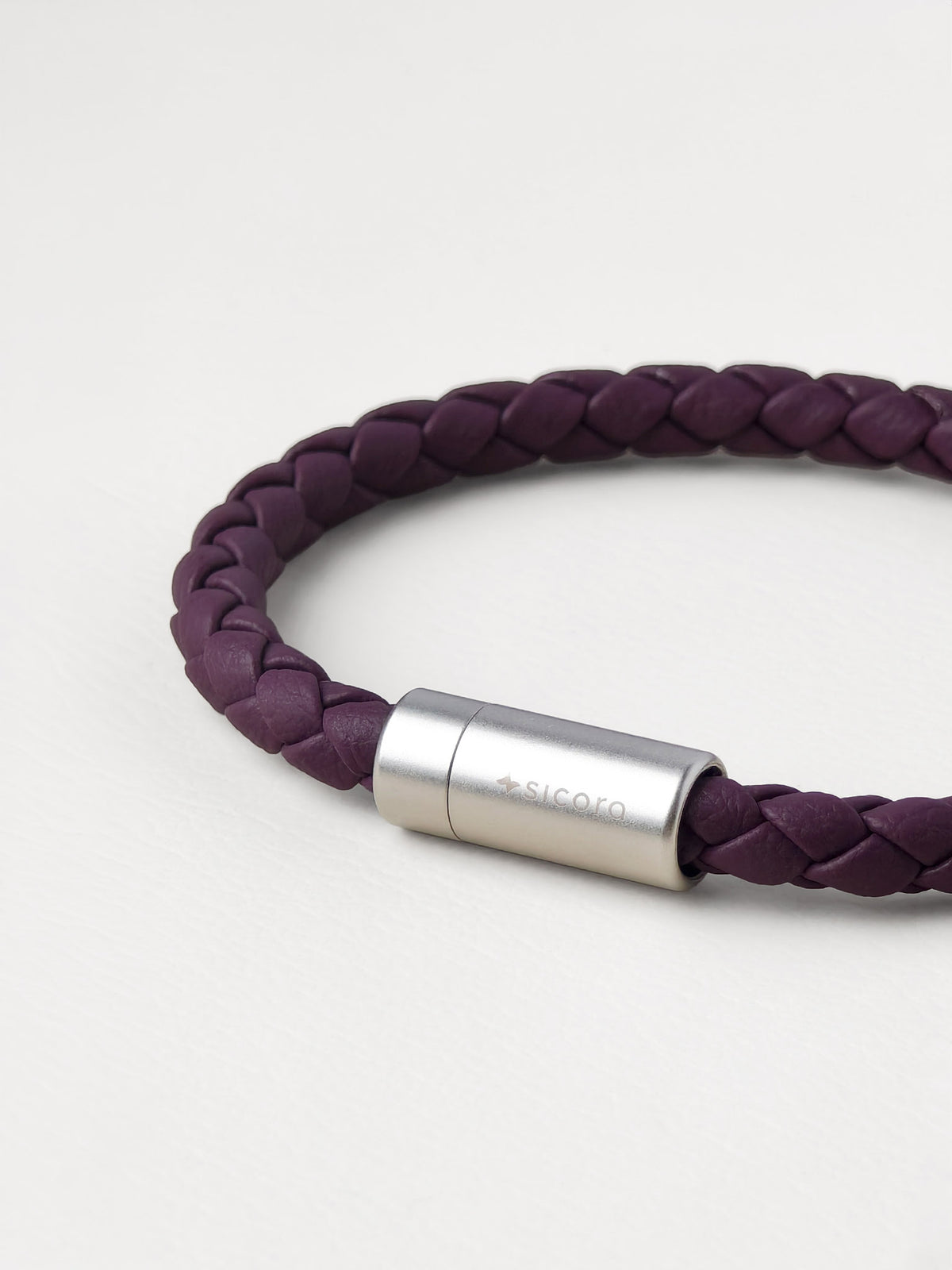 Close-up of a sicora dark cherry purple braided silio silicone vegan leather bracelet with a stainless steel metal magnetic clasp