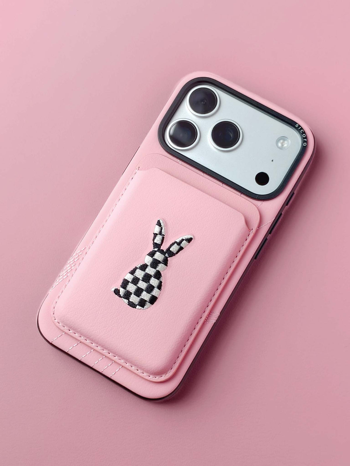sicora vegan leather graphic magnetic card wallet in pink with black and white embroidered rabbit artwork on a sicora iPhone 18 / 17 pro case
