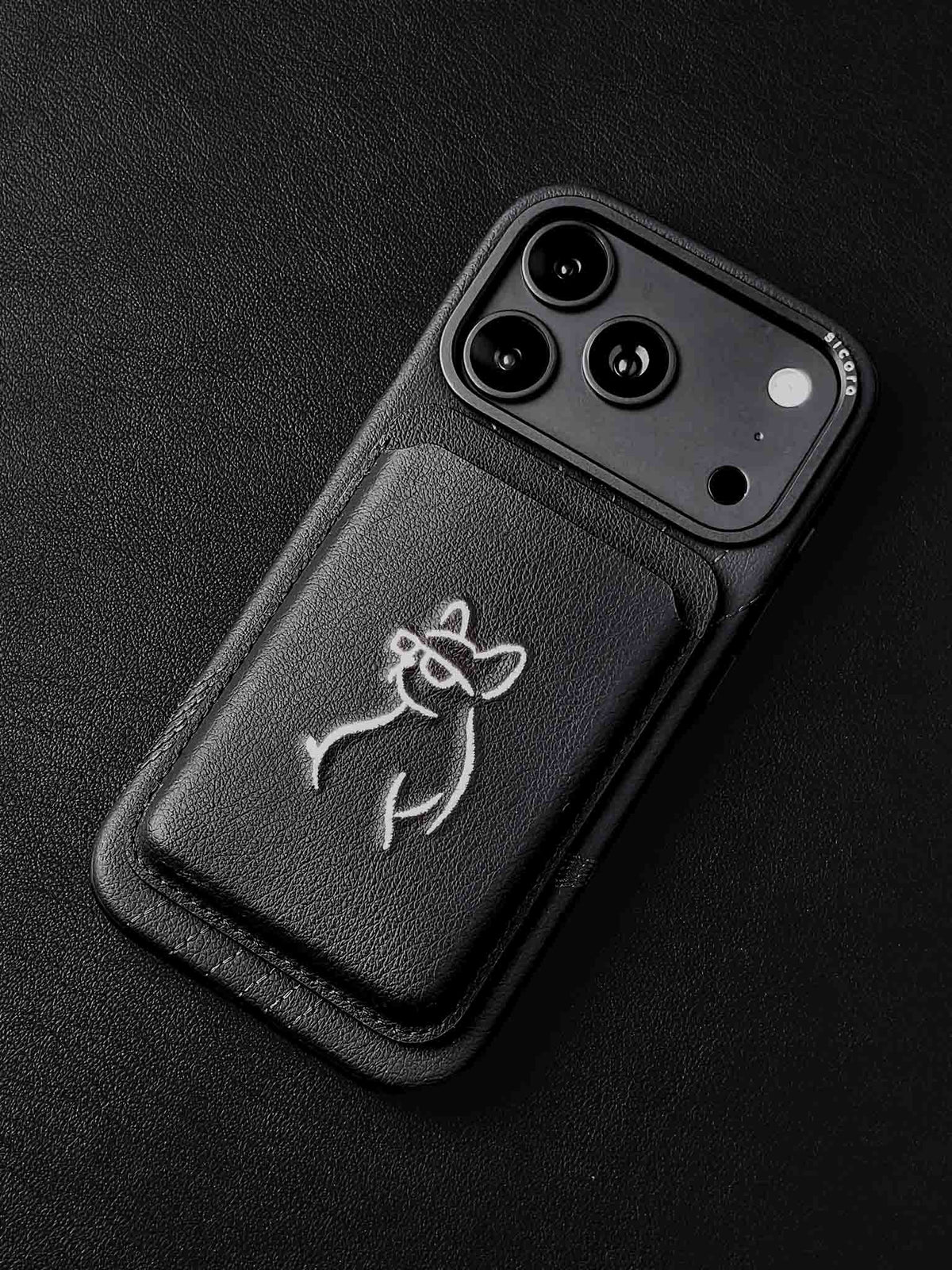sicora vegan leather graphic magnetic card wallet in black with cream white embroidered dog line-drawing on a sicora iPhone 18 pro case