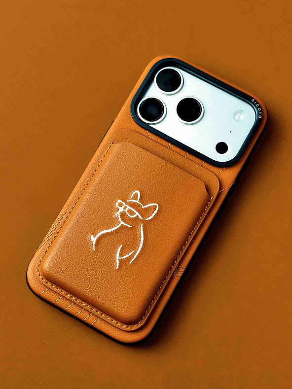 sicora vegan leather graphic magnetic card wallet in toffee gold brown with cream white embroidered dog line-drawing on a sicora iPhone 18 / 17 pro case