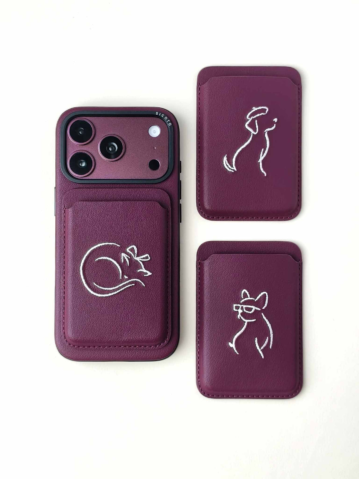 Flat-lays of cherry purple sicora vegan leather accessories: iPhone 18 / 17 pro case, and graphic magnetic card wallets