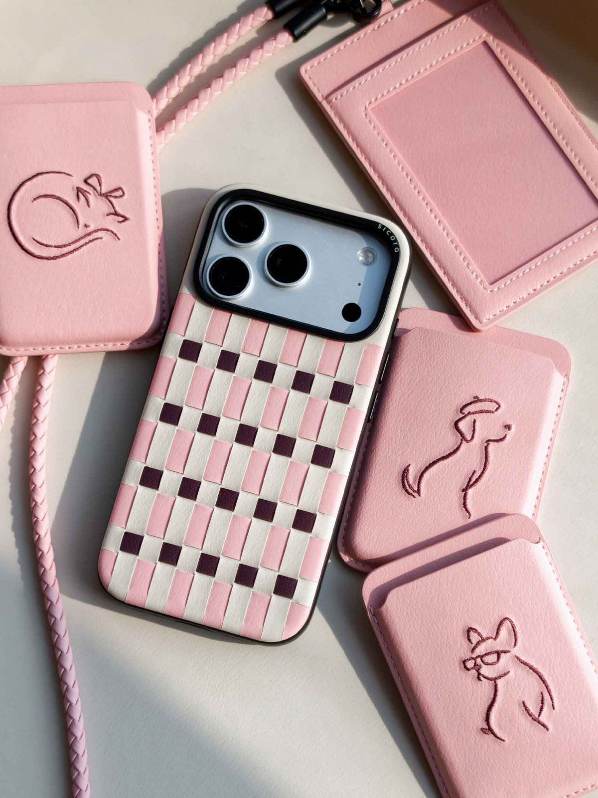Flat-lays of pink sicora vegan leather accessories: iPhone 18 / 17 pro case, magnetic card wallets, and ID badge holder with lanyard