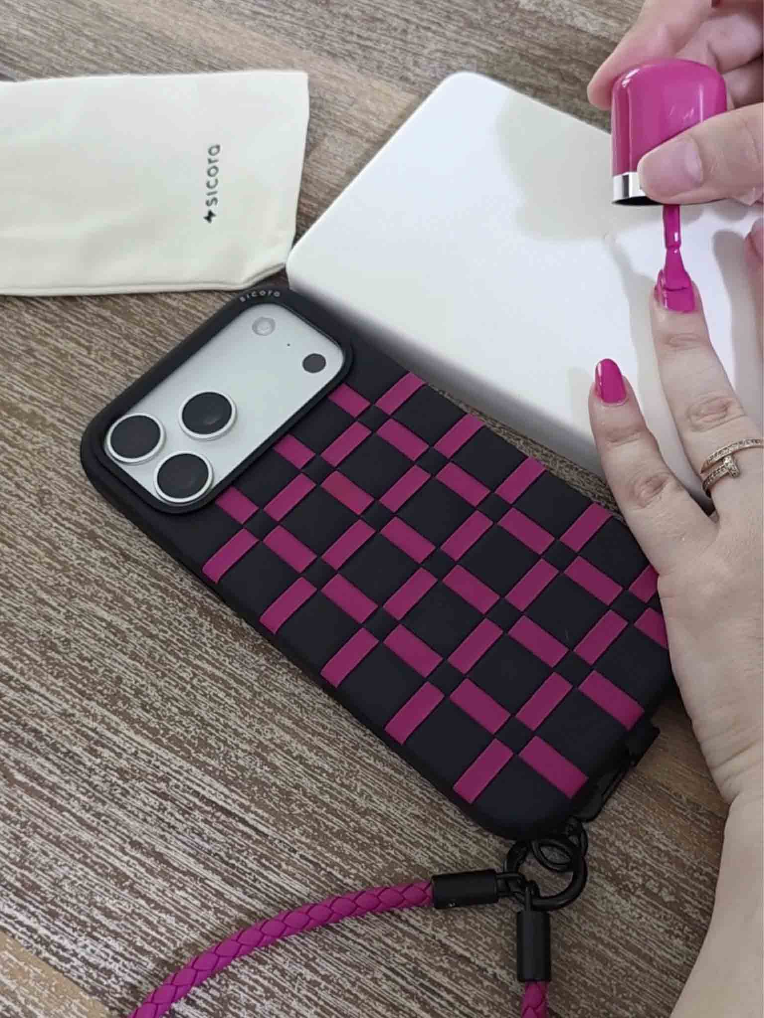 Black magenta pink sicora gridplay iPhone case on a desk