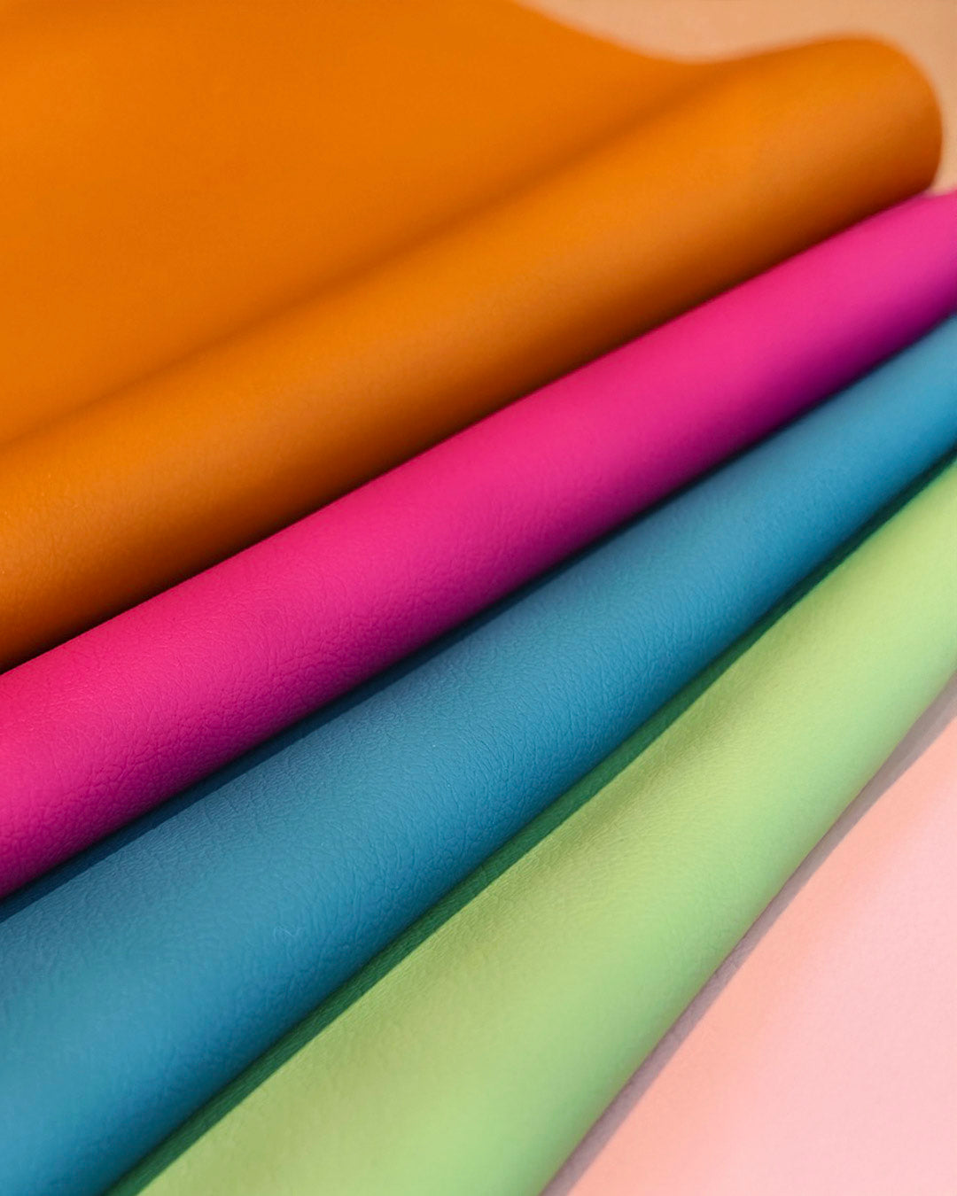 Close-up of colorful SILIO leather swatches in toffee, magenta, blue, green, and pink.