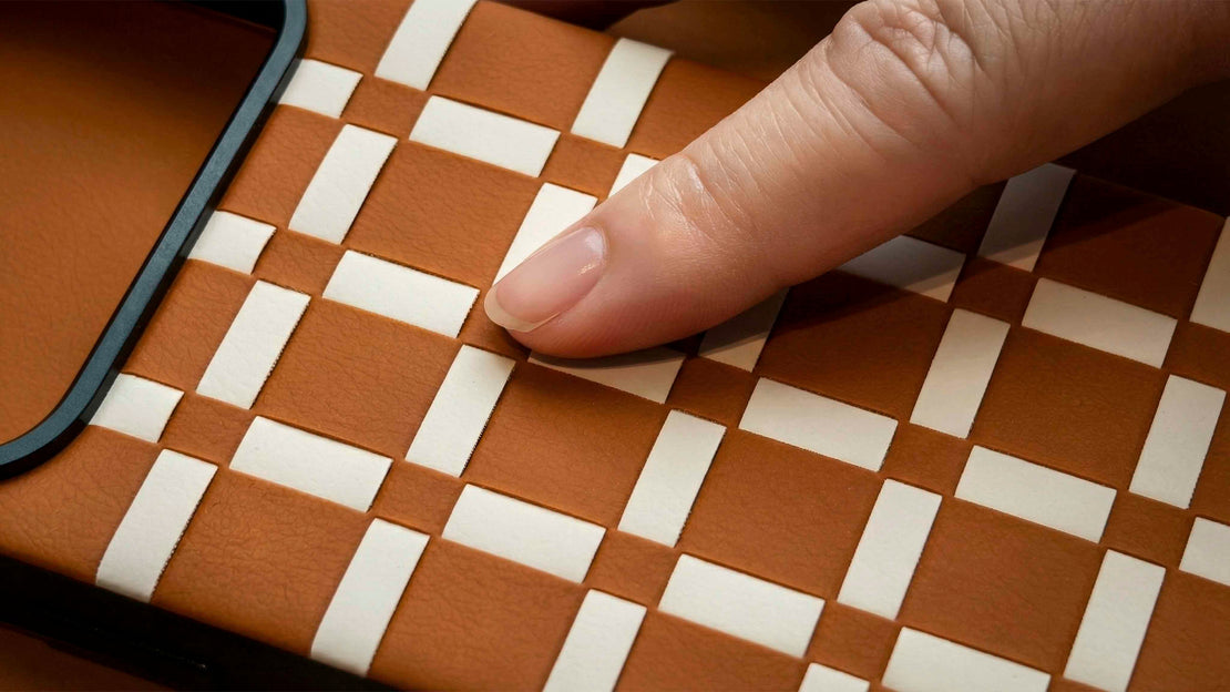 Hand touching a woven brown and white patterned SILIO leather