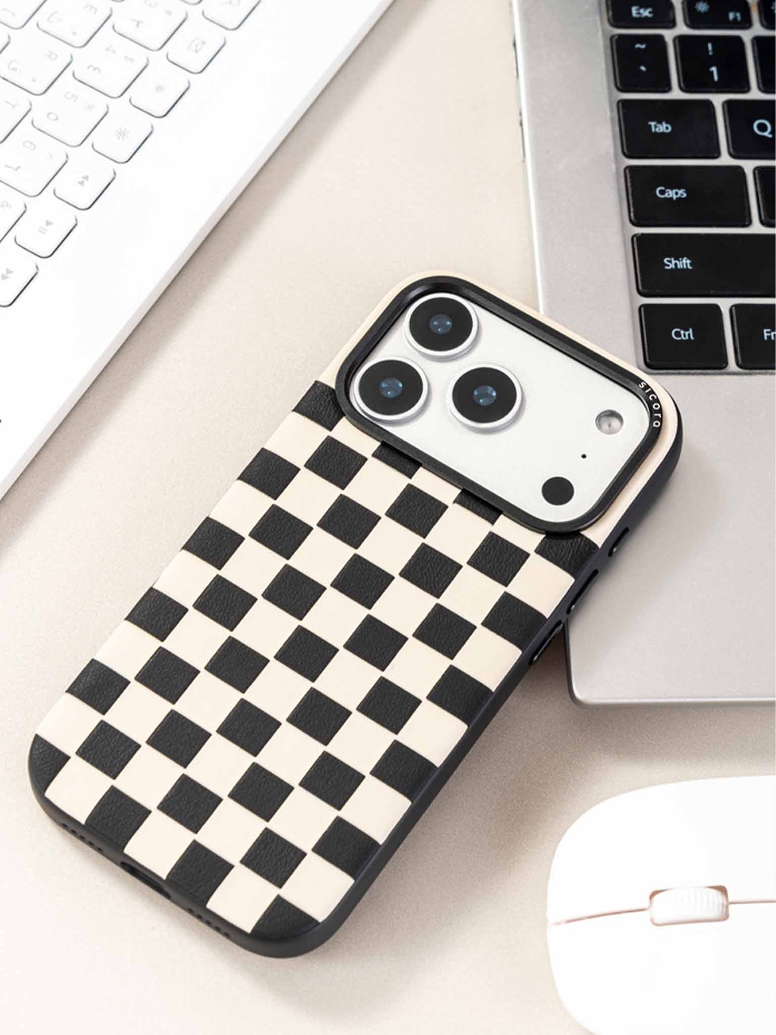 Sicora checkerboard phone case with black and cream white checkered pattern on a desk with keyboard and mouse