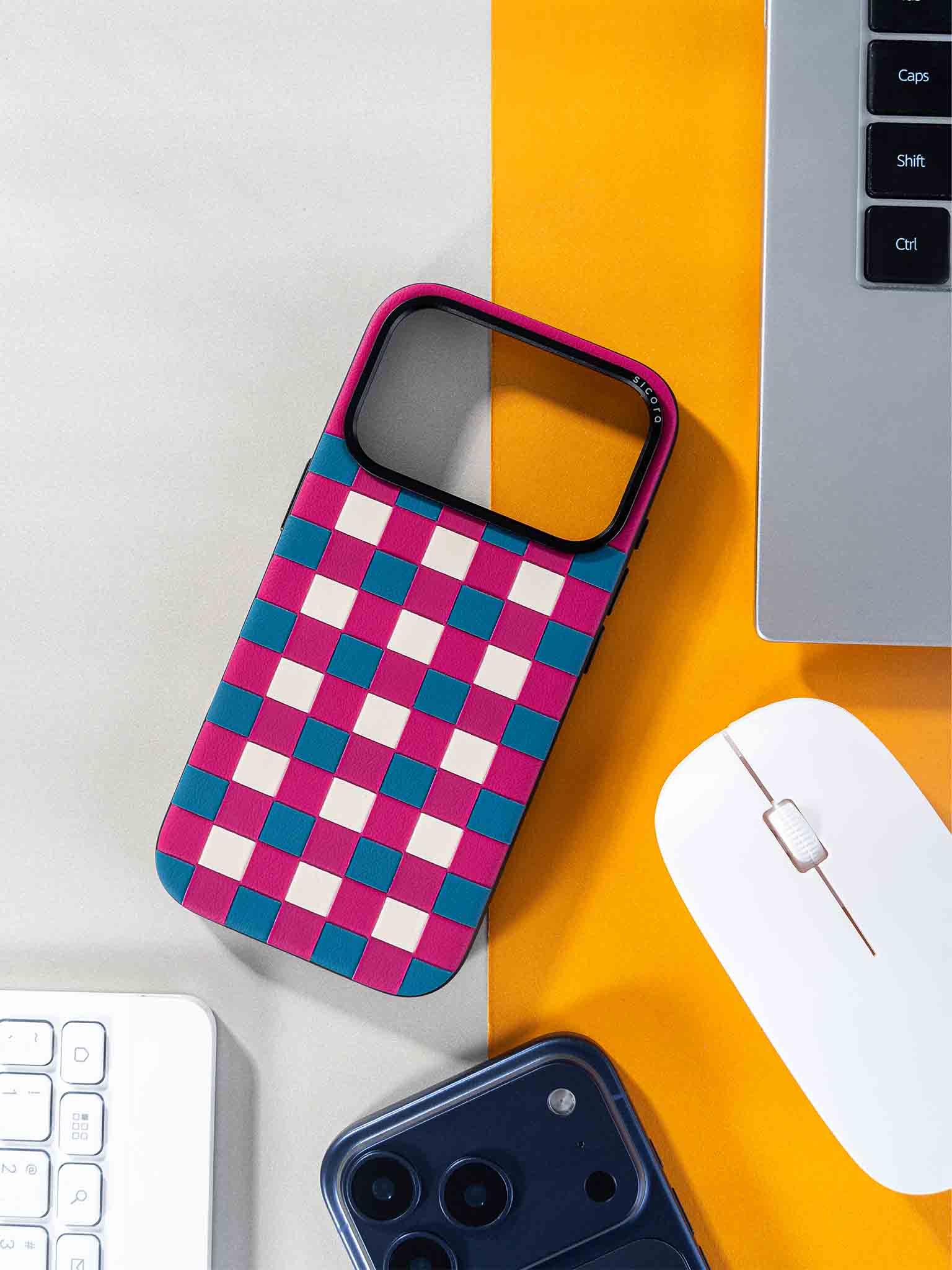 Sicora checkerboard phone case with magenta, sea blue and cream white checkered pattern with a laptop and mouse