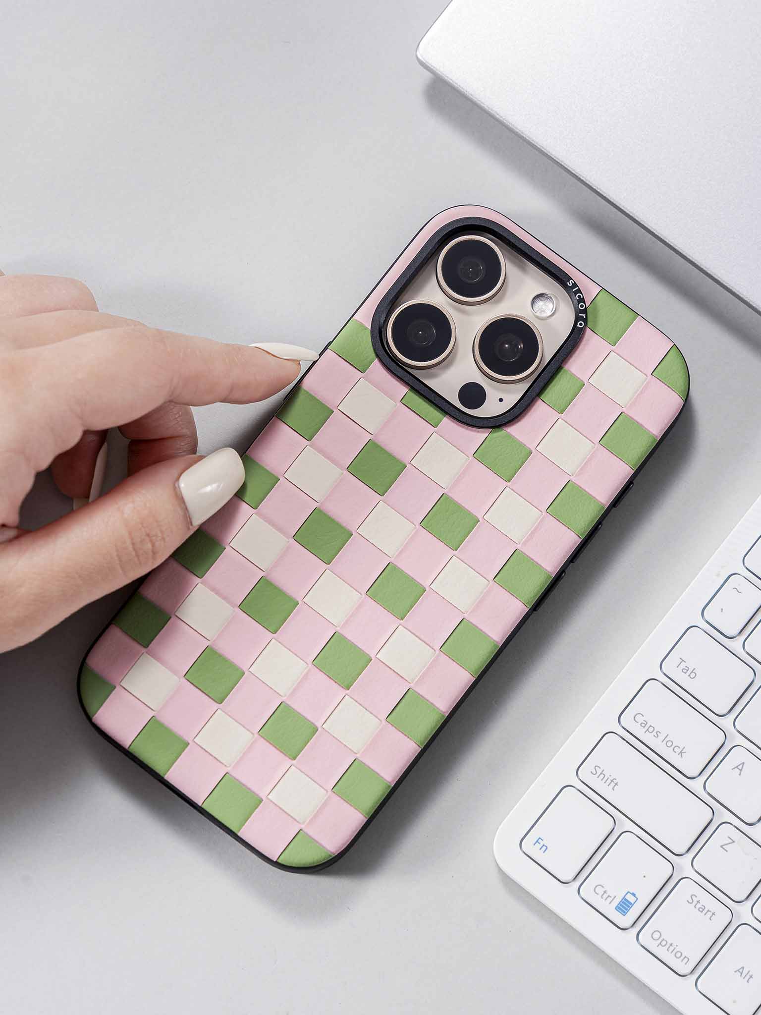 sicora pink green white checkerboard phone case on a desk