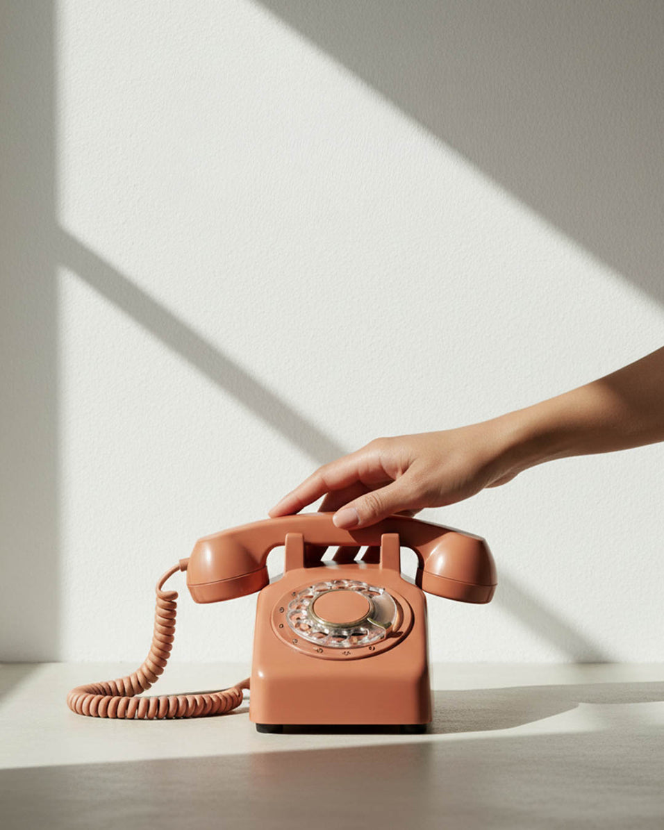 A composition of a hand picking up a retro phone, conveying a friendly idea of reaching out and contacting sicora support team.