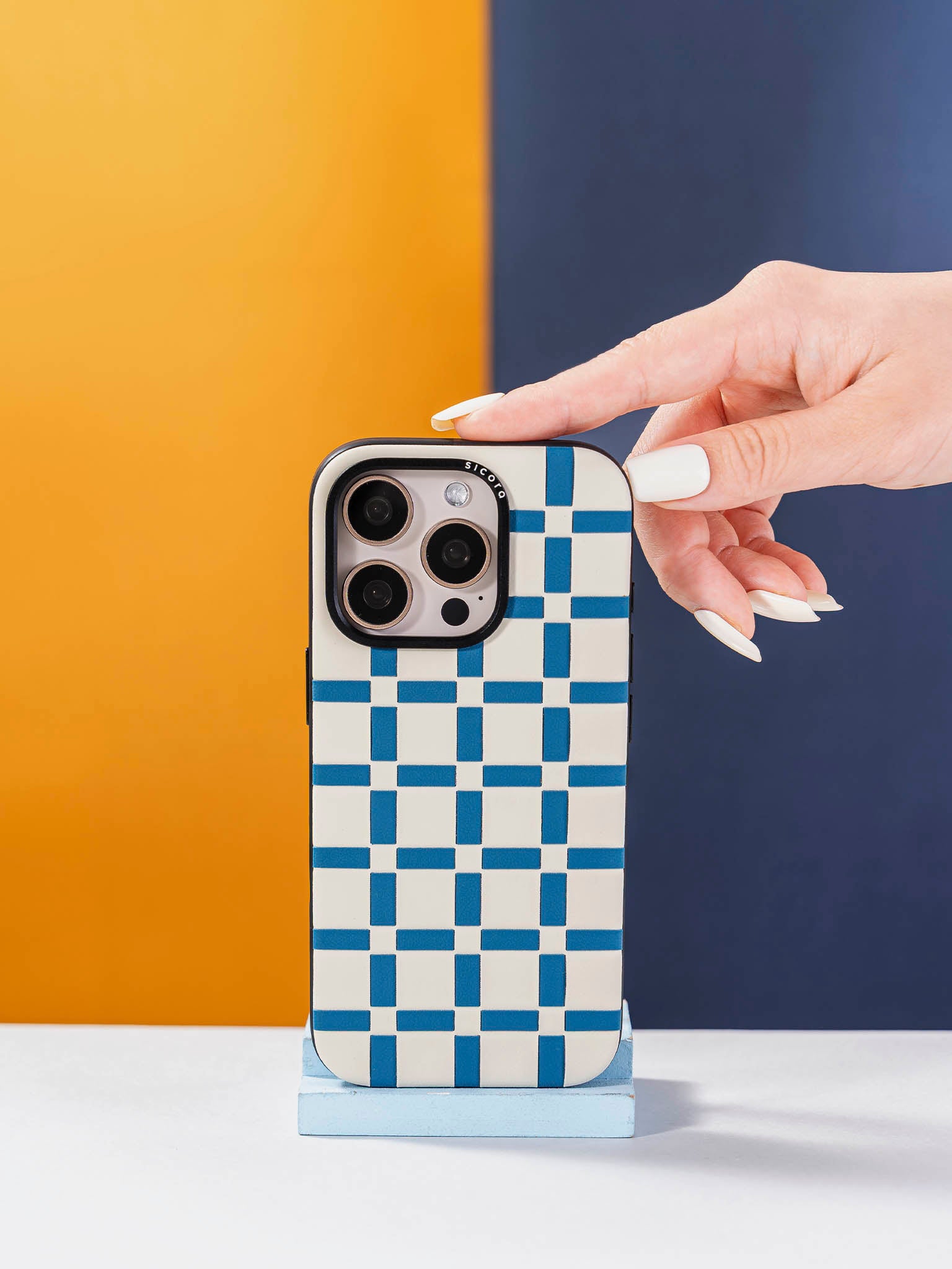fingers touching a sicora blue and white handwoven gridplay iphone case