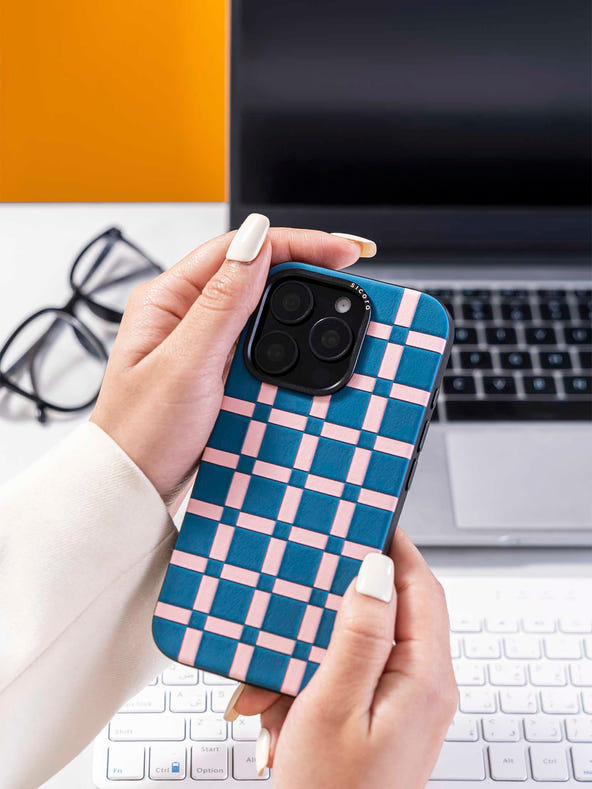 Hands holding a sicora blue and pink handwoven gridplay iphone case