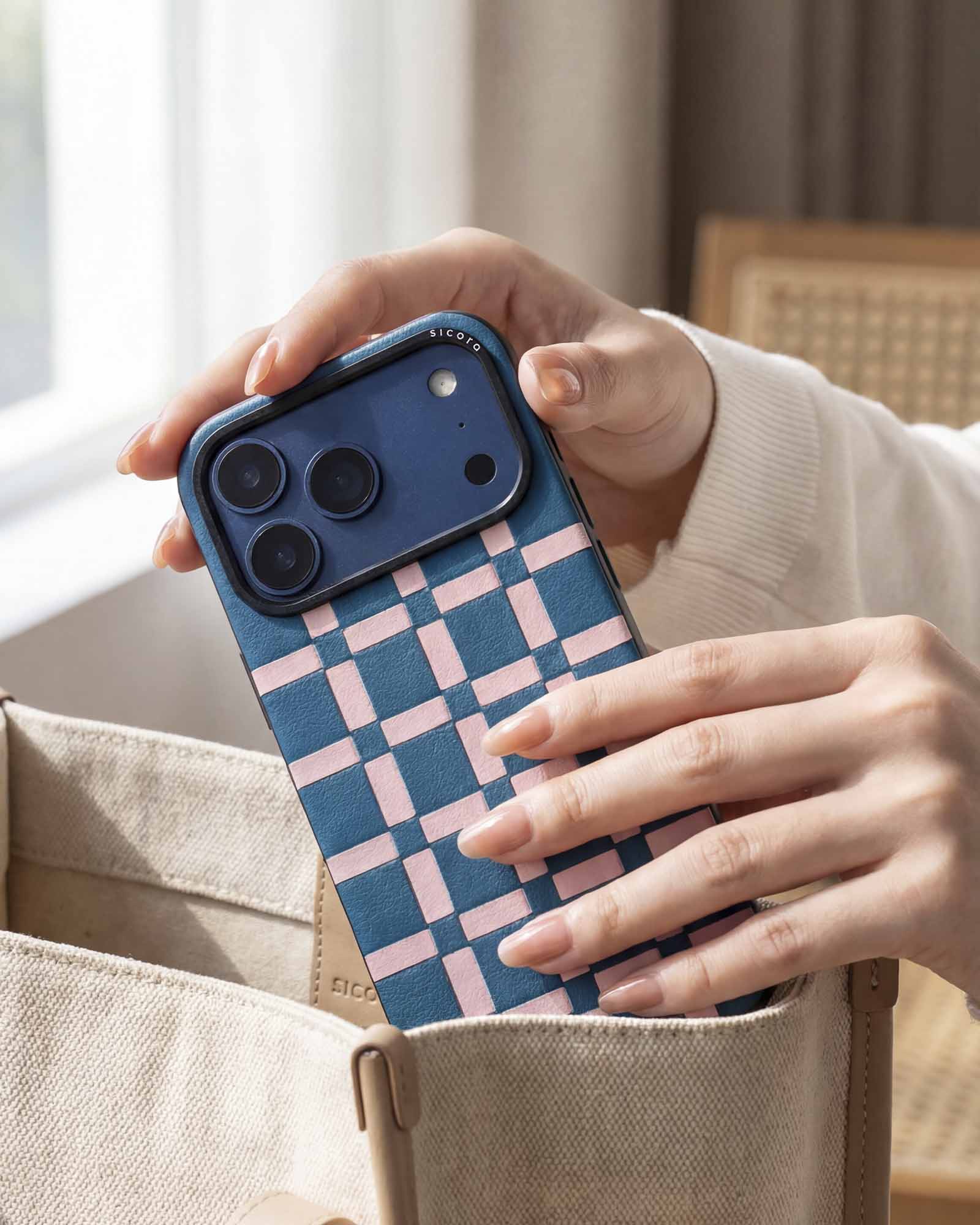 Person holding a sicora blue and pink gridplay case in a casual setting.