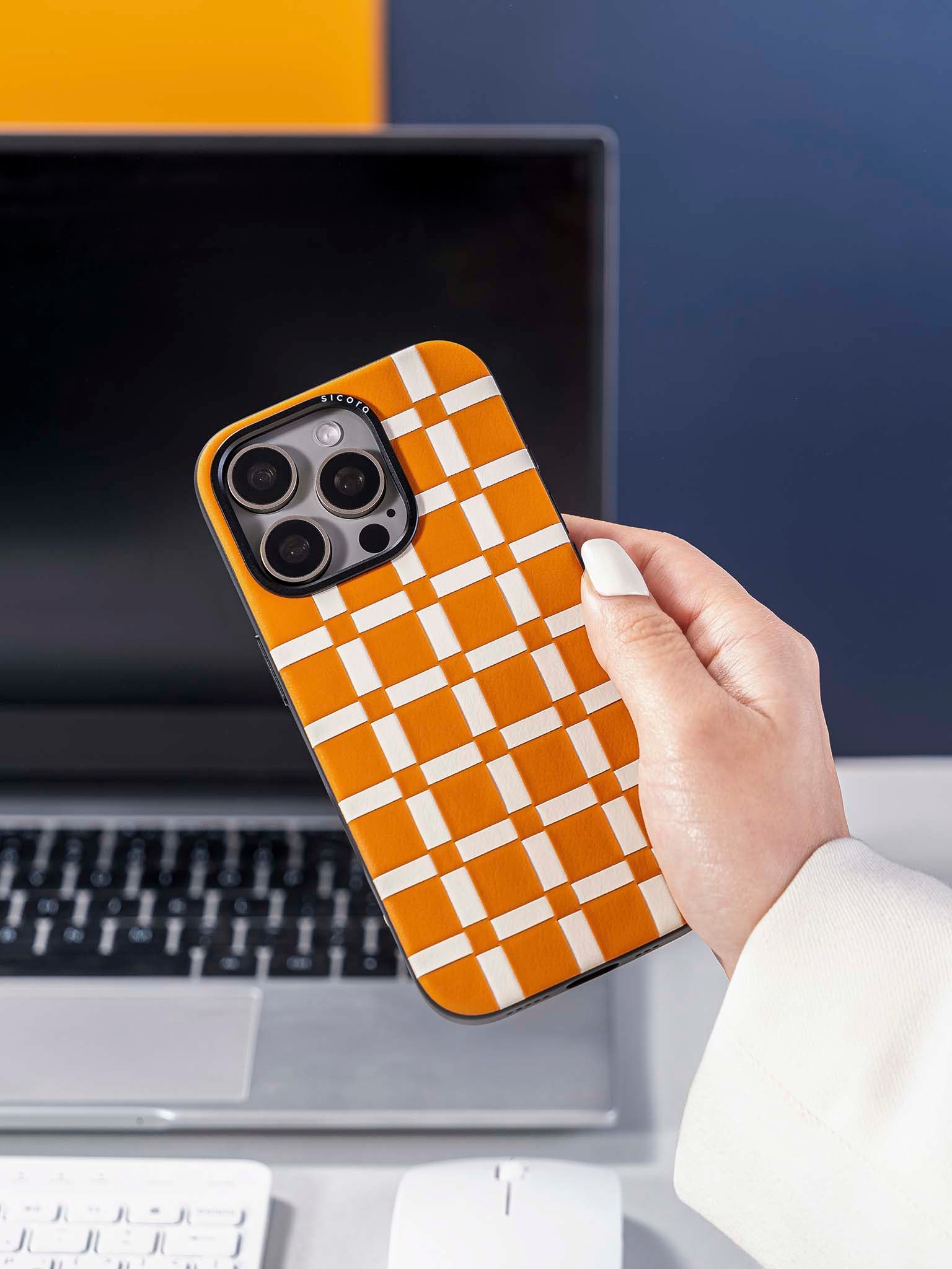 Hand holding a sicora brown and white gridplay phone case