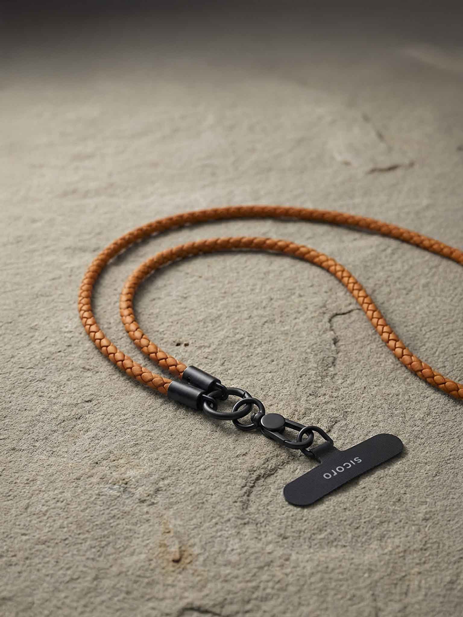 sicora braided leather lanyard with black clasp on a textured surface