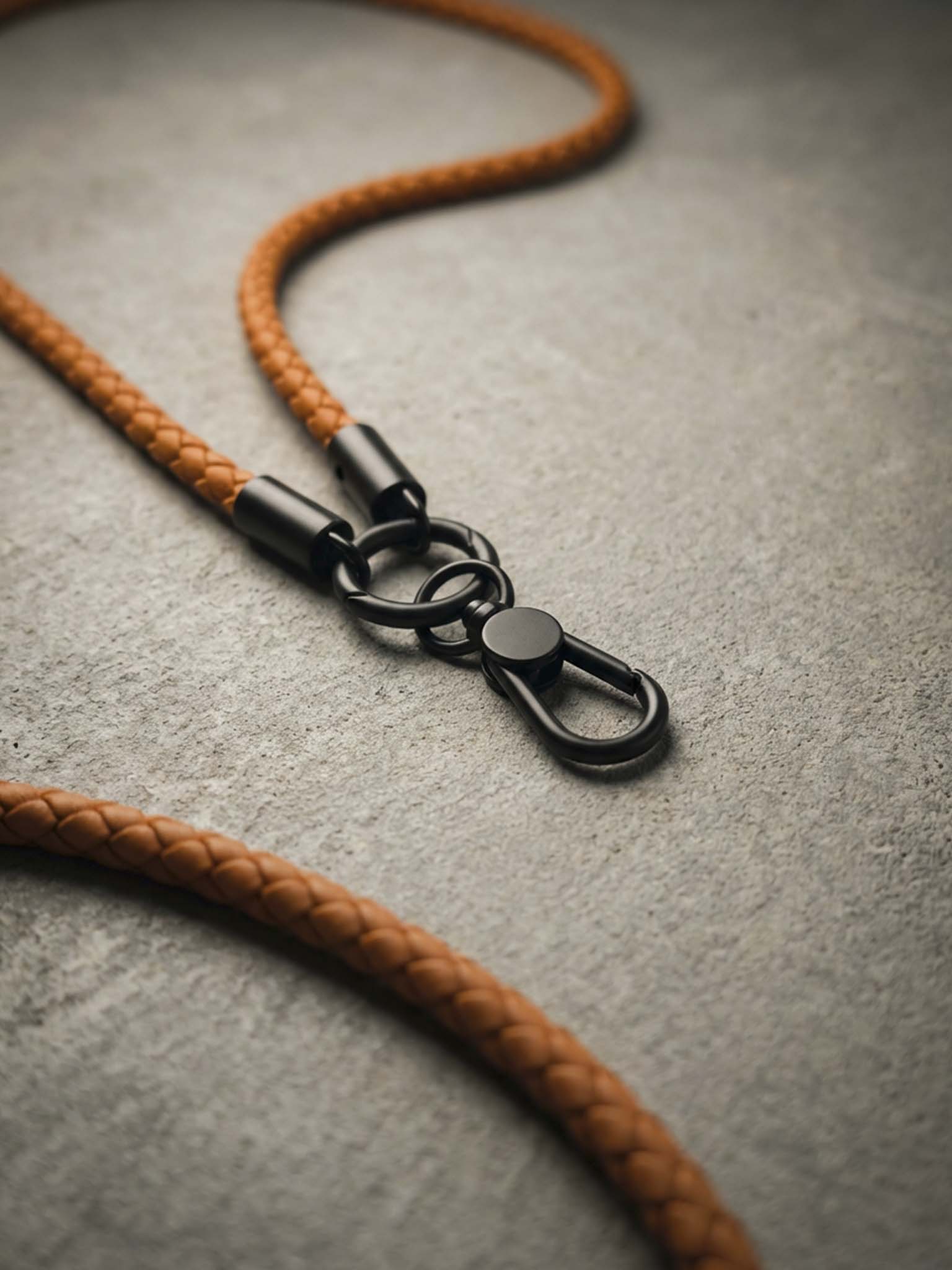 sicora toffee brown braided leather lanyard with black metal clip on a gray surface