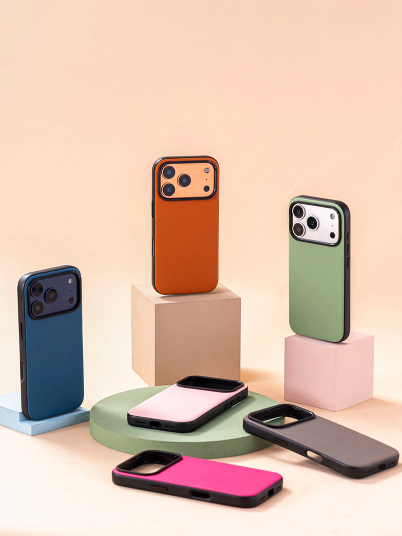 Collection of colorful sicora moodblock phone cases on geometric stands against a beige background