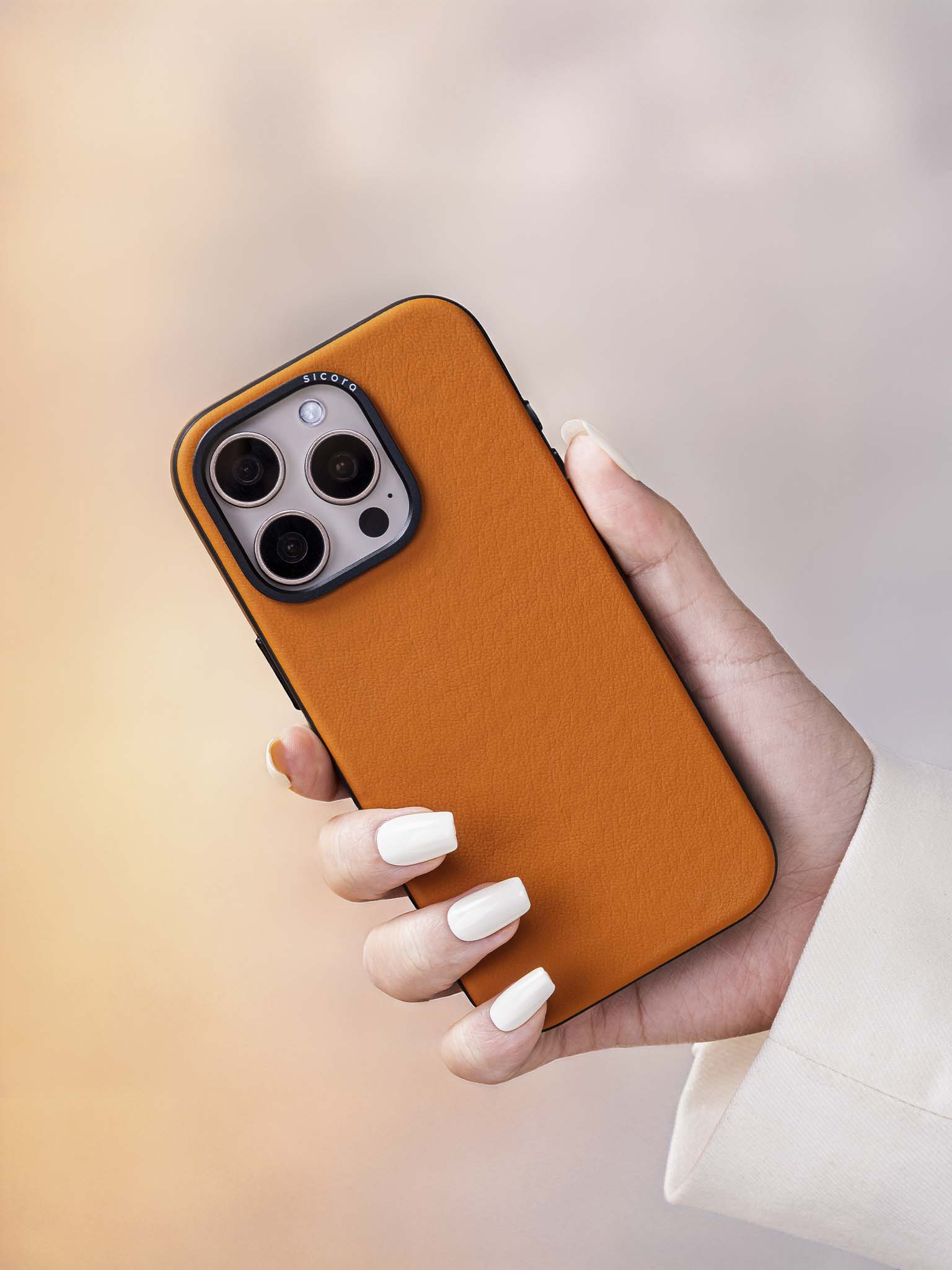 Hand holding a toffee brown sicora handmade vegan leather iPhone case