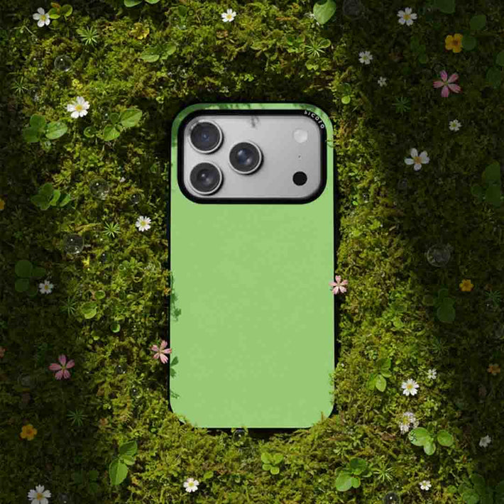 Avocado green sicora iphone case on a grassy background with flowers, eco friendly and sustainable tech accessory