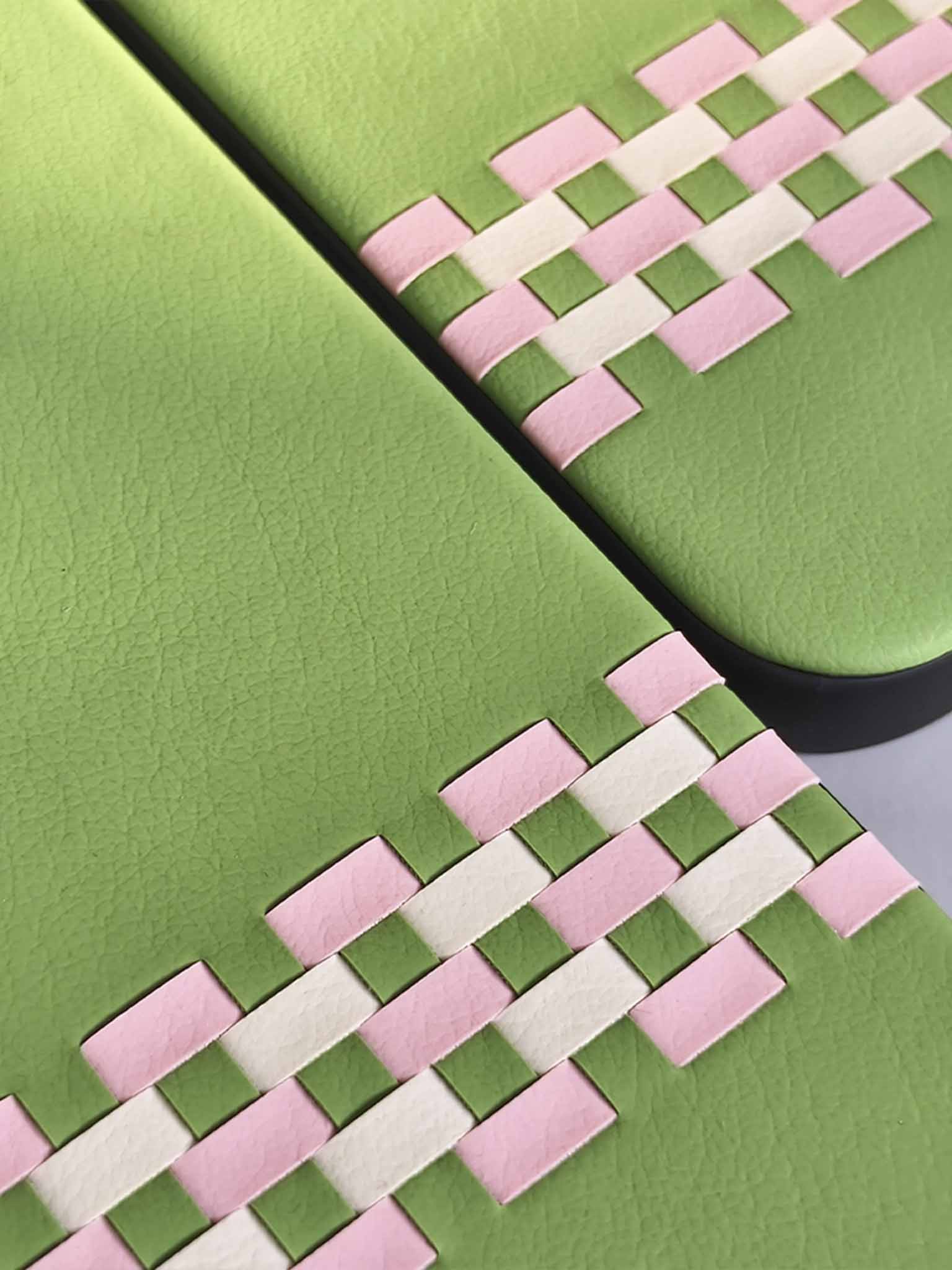 Close-up of sicora  green and pink woven stitchon pattern on a flat surface