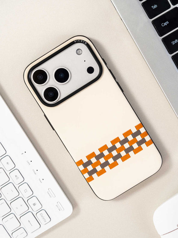 Sicora stitchon phone case with cream white, toffee gold and granite gray geometric pattern on a desk