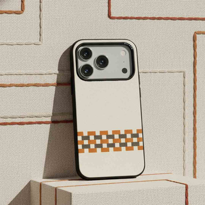 A sicora stitchon iPhone case with cream white, toffee gold and granite gray geometric pattern in silio silicone vegan leather on a textured surface