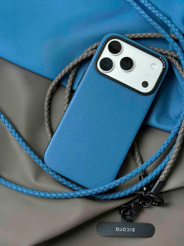 A blue sicora moodblock iPhone 17 pro case with braided lanyards and black carabiner.