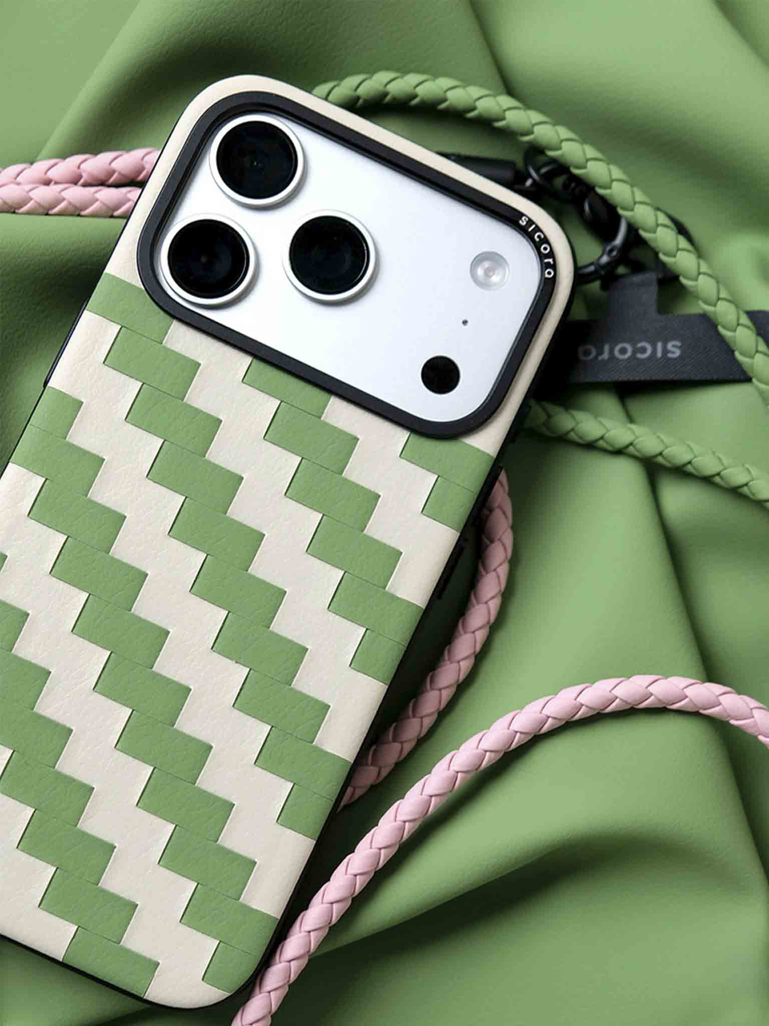 A green sicora zigzag iPhone 17 pro case with braided lanyards and black carabiner.