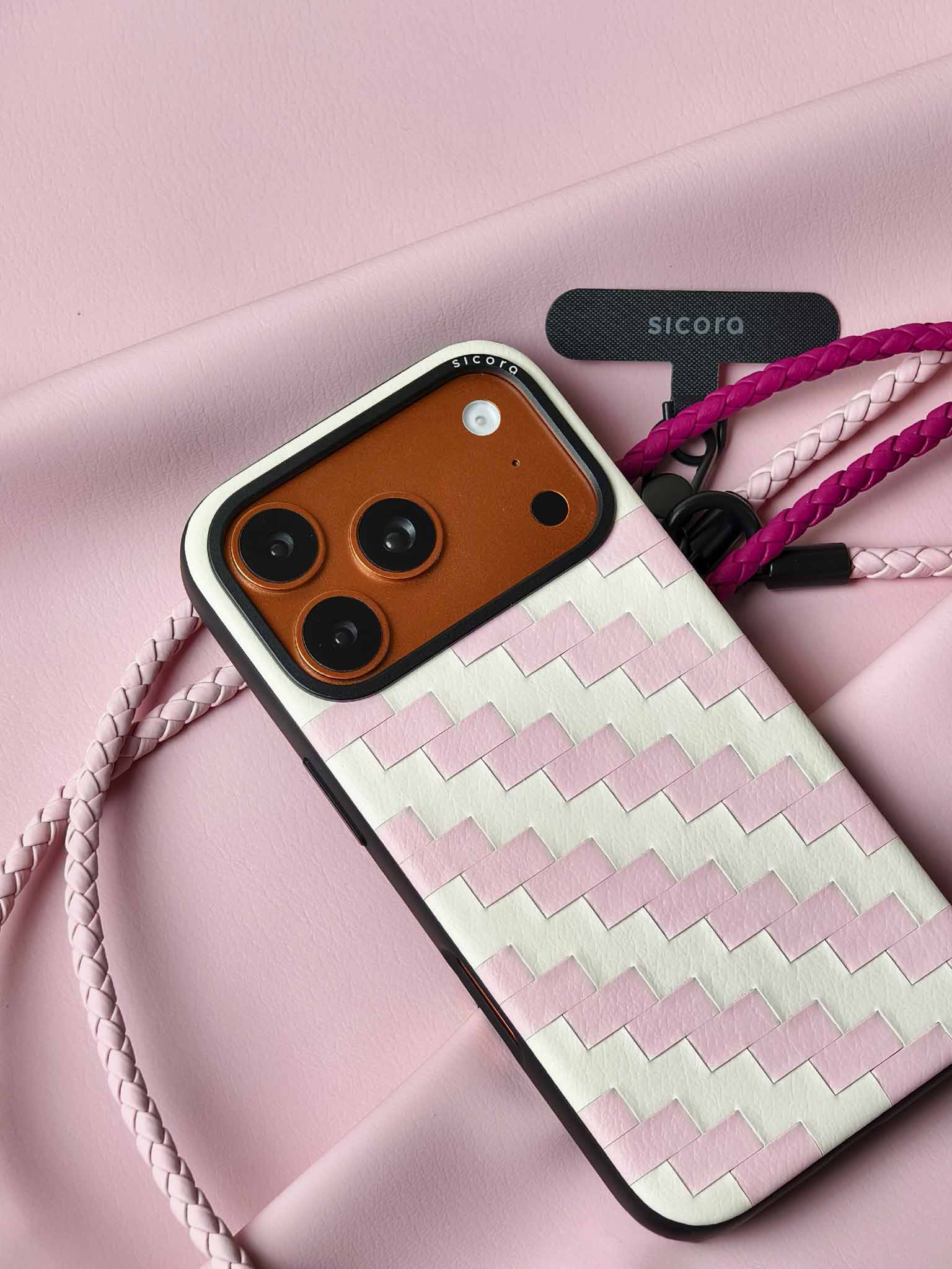 A pink sicora zigzag iPhone 17 pro case with braided lanyards and black carabiner.
