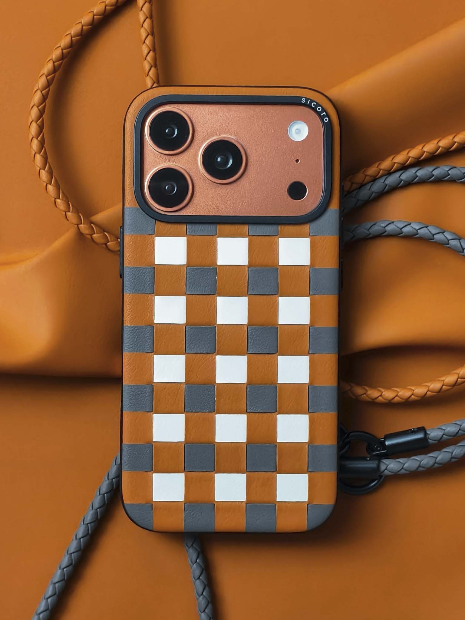 An orange brown sicora zigzag iPhone 17 pro case with braided lanyards.