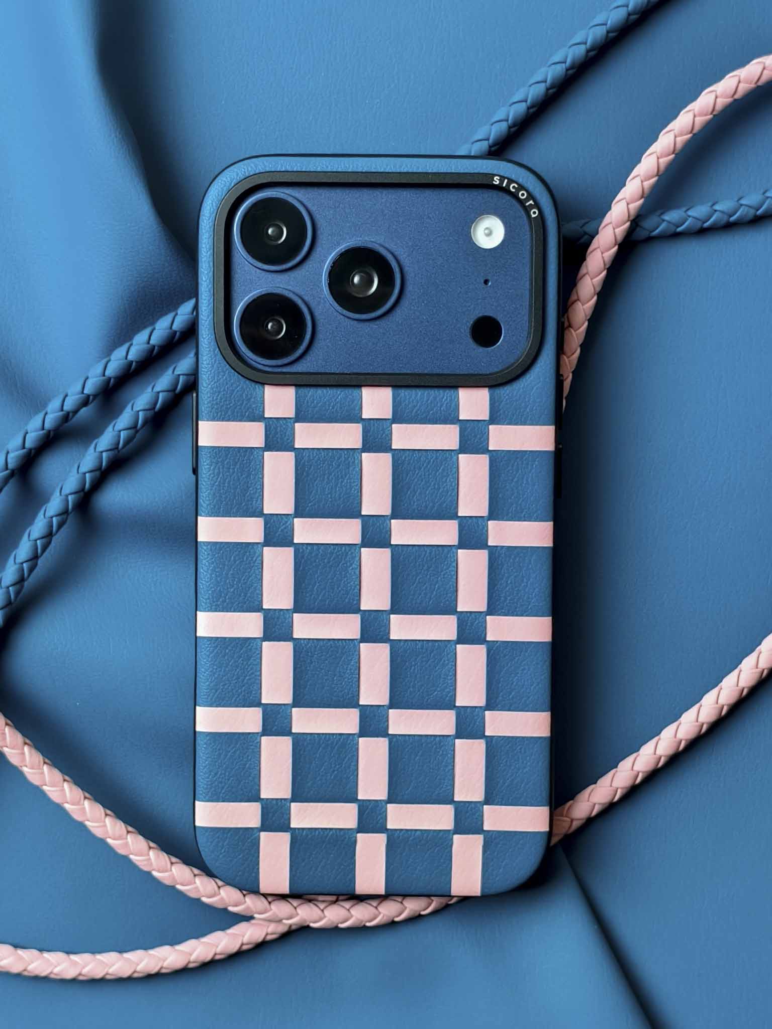 A blue sicora gridplay iPhone 17 pro case with braided lanyards and black carabiner.