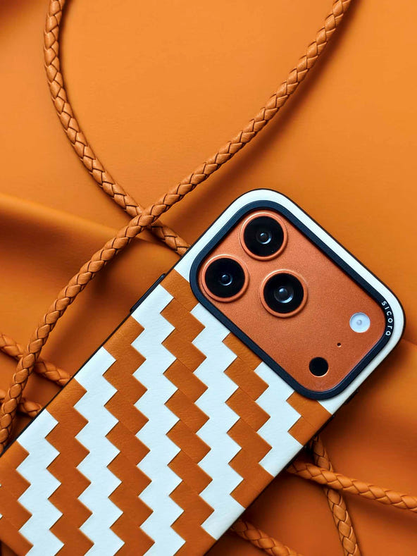 An orange brown sicora zigzag iPhone 17 pro case with braided lanyards.