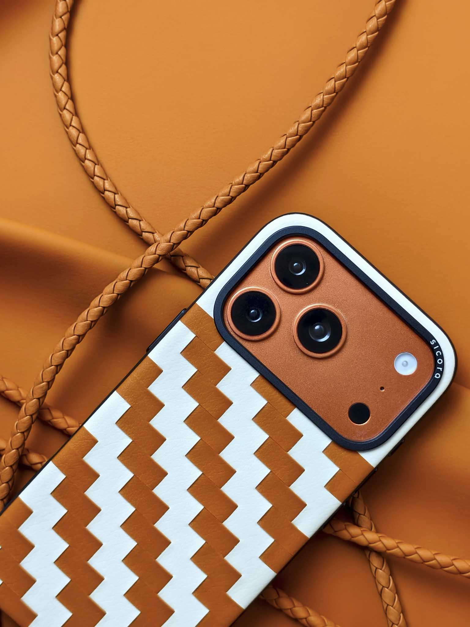 An orange brown sicora zigzag iPhone 17 pro case with braided lanyards.