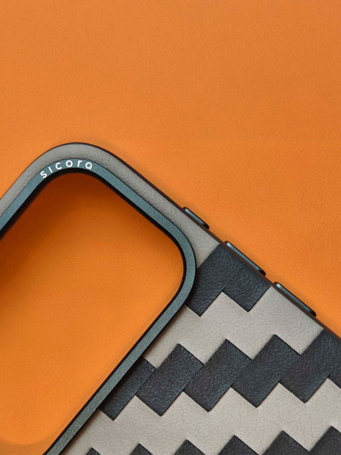Close-up of a phone case with zigzag pattern on an orange background
