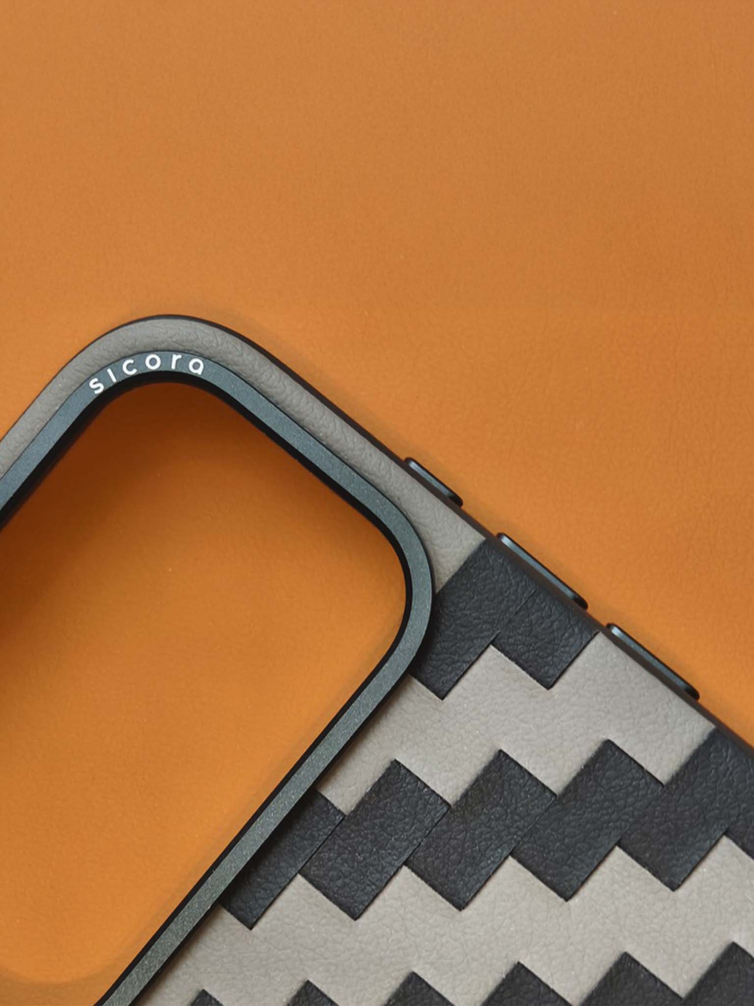 Close-up of a phone case with zigzag pattern on an orange background