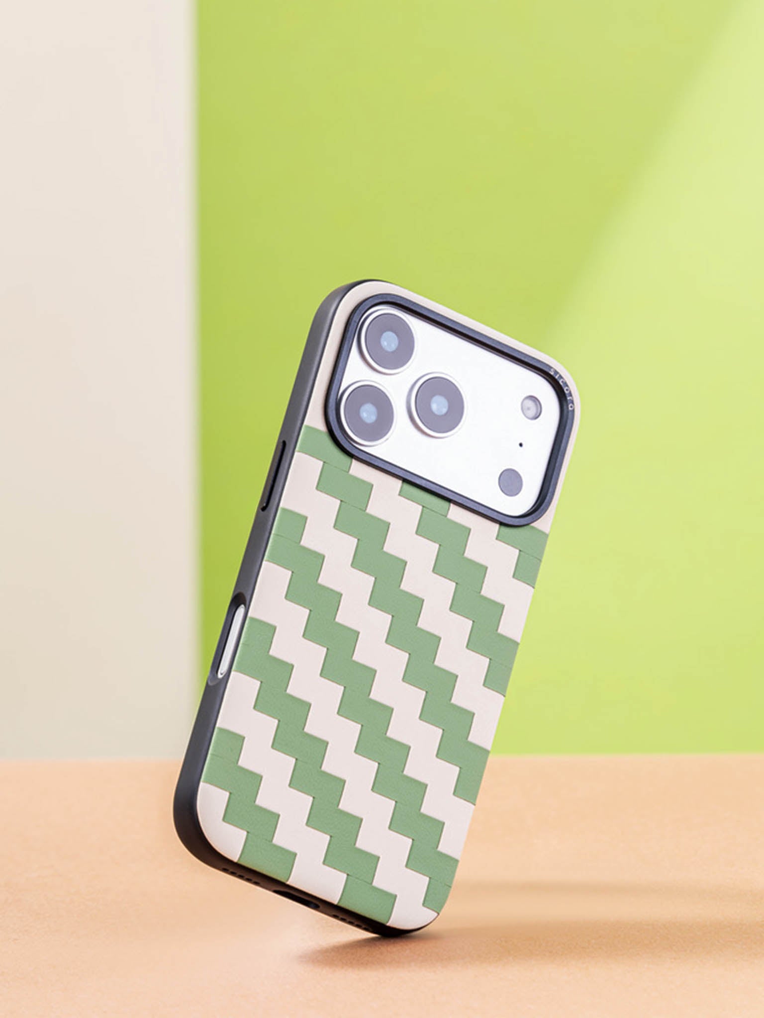 Sicora zigzag phone case with avocado green and cream white zigzag pattern on a colorful background