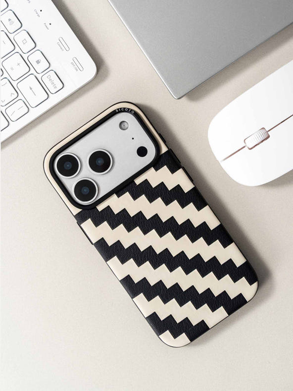 Sicora zigzag phone case with black and cream white zigzag pattern on a desk with keyboard and mouse.
