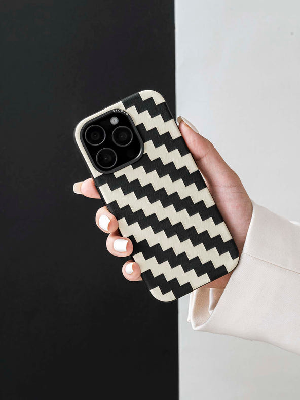 Hand holding a sicora black and white zigzag iphone case