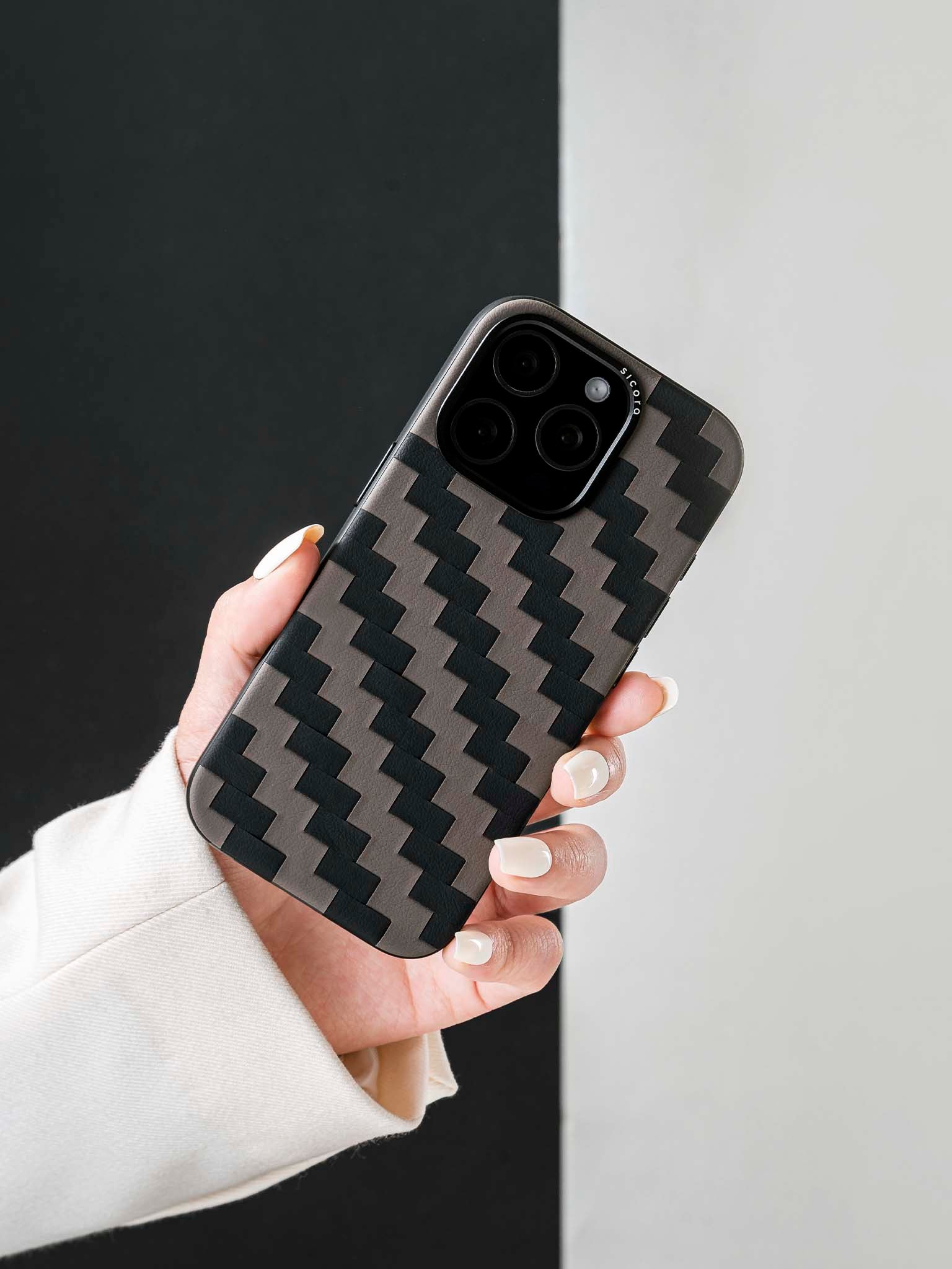 Hand holding a sicora black and gray zigzag iphone case